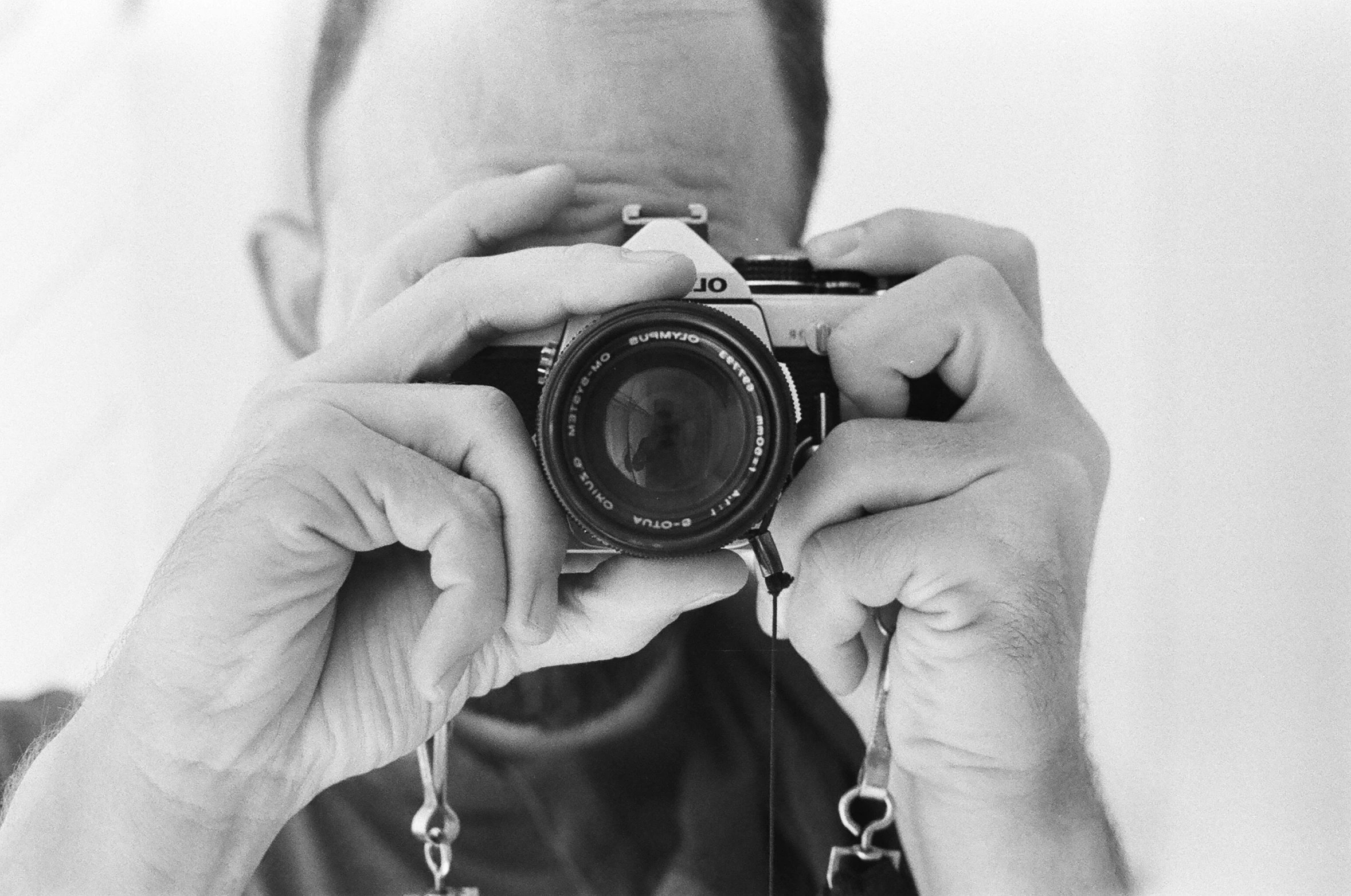 a black and white po of a man taking a selfie with a camera