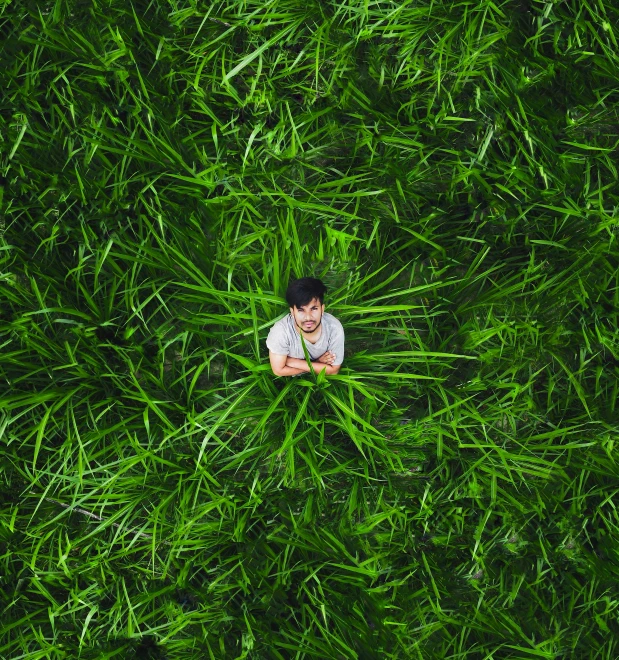 young man laying down on grass looking up