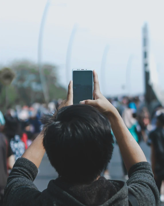 the person is using his cell phone in front of some people