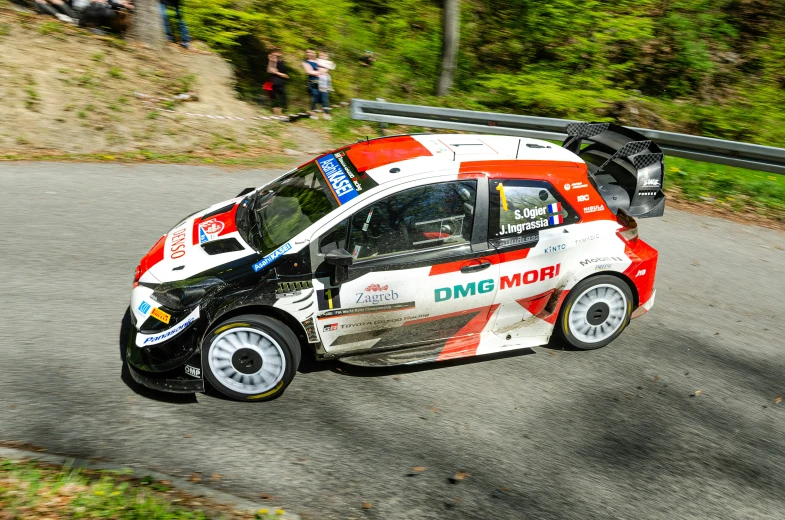 a small white and red car driving on a road