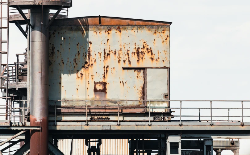 an old rusted up building sits along a river