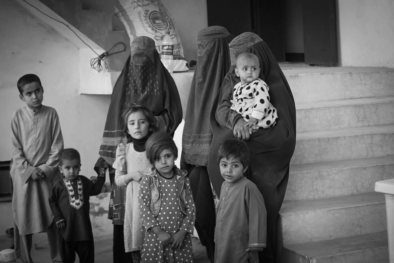 some children posing for a black and white po with other children