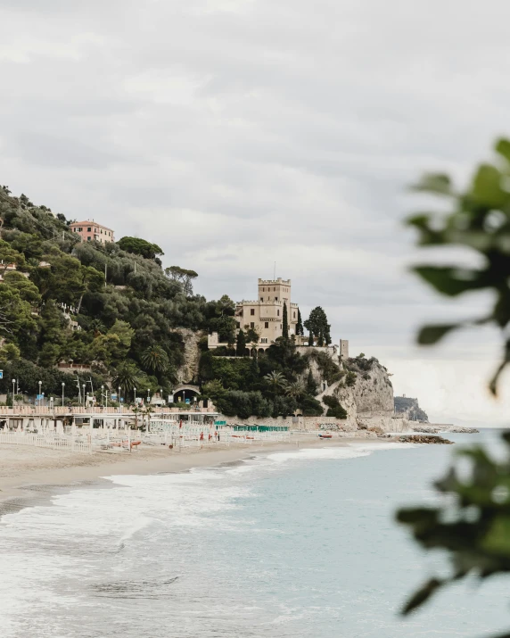 a view of a beach on the coast near a hillside