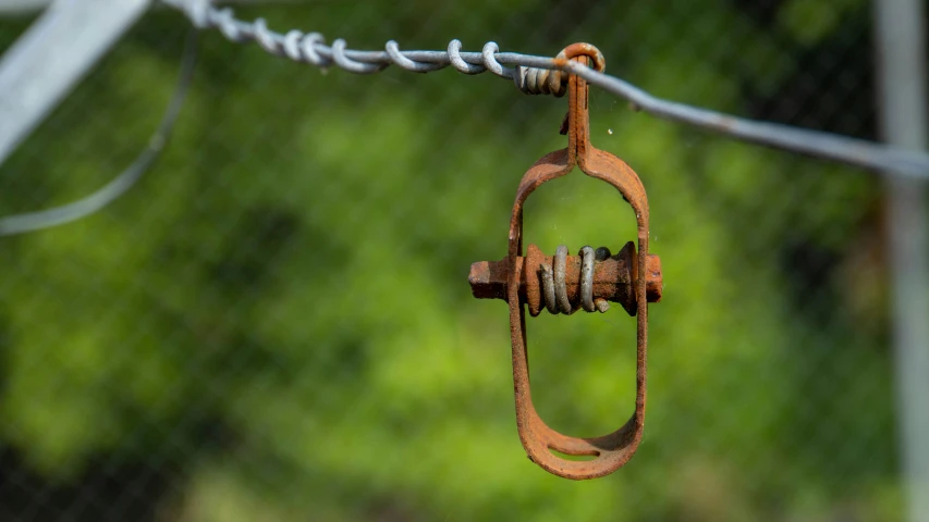 an old rusted wire is hanging from a gate with barbed wire