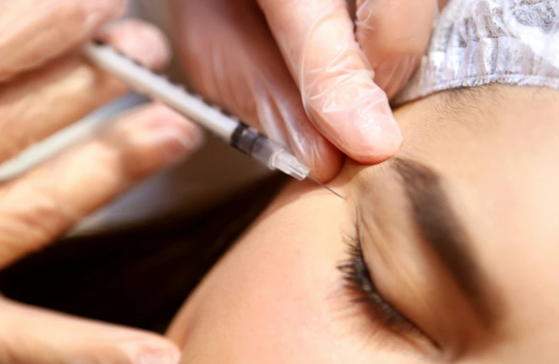 a woman getting a brow laser applied on her face