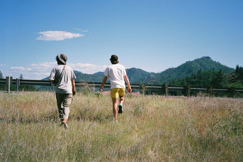 a man and a woman are walking through a field together