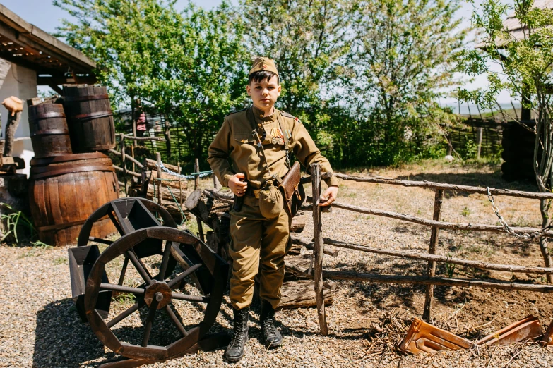 a man is standing next to an old wheel