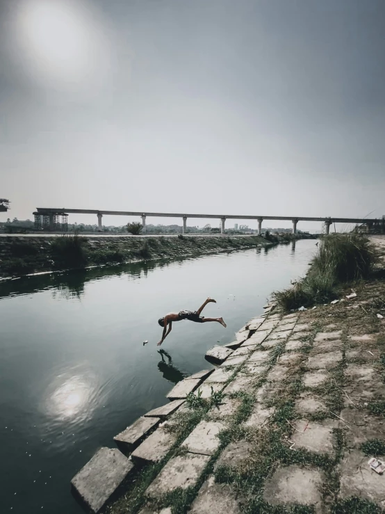 a person jumping into a body of water