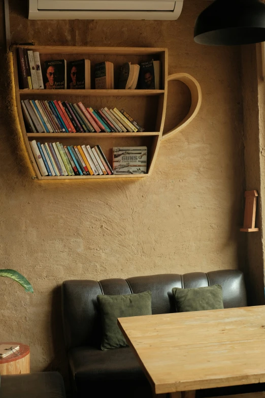 the interior of a restaurant with a wooden table and bookshelf