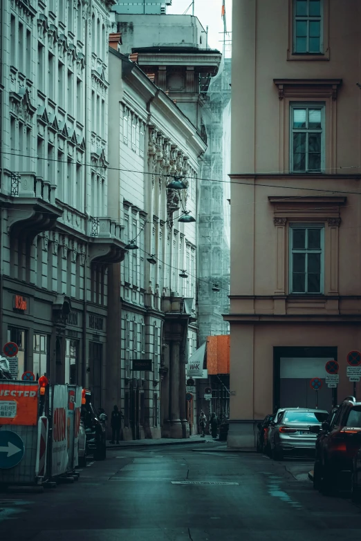 a street scene of old city buildings, vehicles and pedestrians