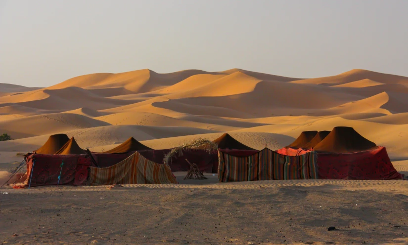 a couple tents are in the sand