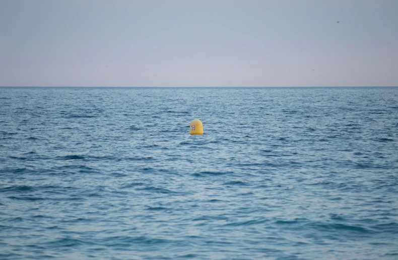 the blue ocean is filled with some big yellow floats