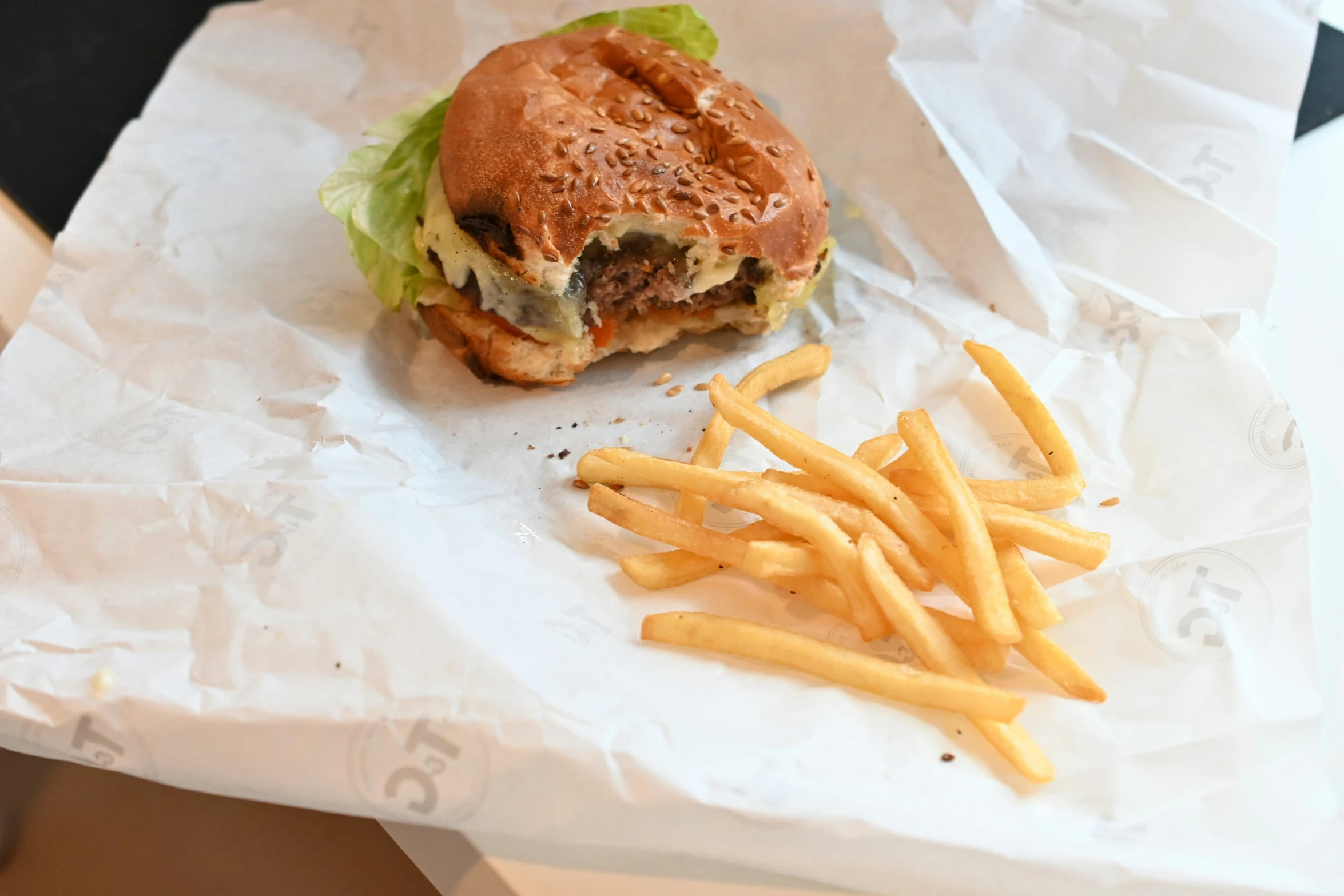 a sandwich and french fries sitting on top of white paper