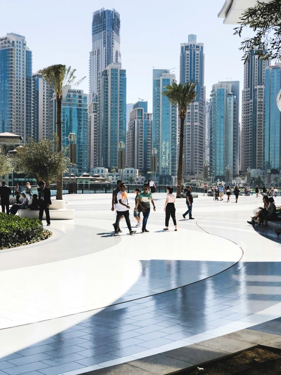 some people are skateboarding in front of tall buildings