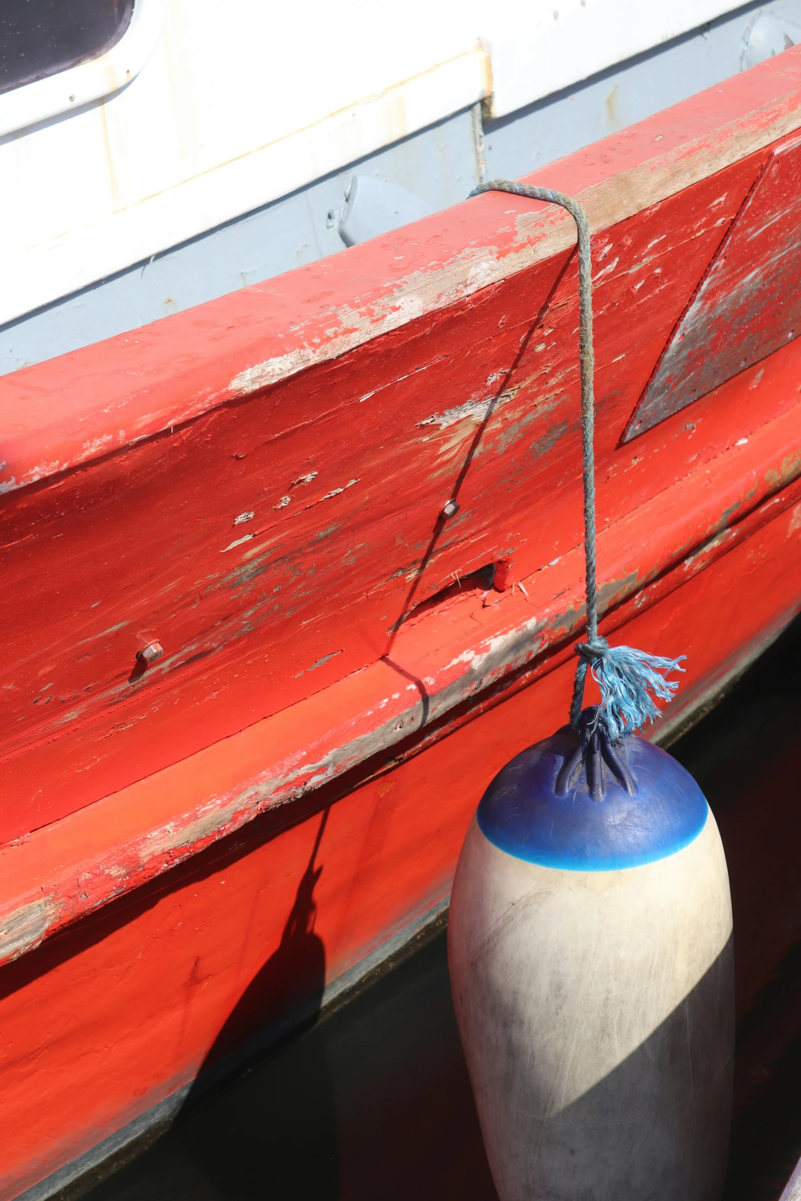 the blue and white vase is by the orange boat