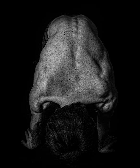 a person with their back turned sideways at a black background