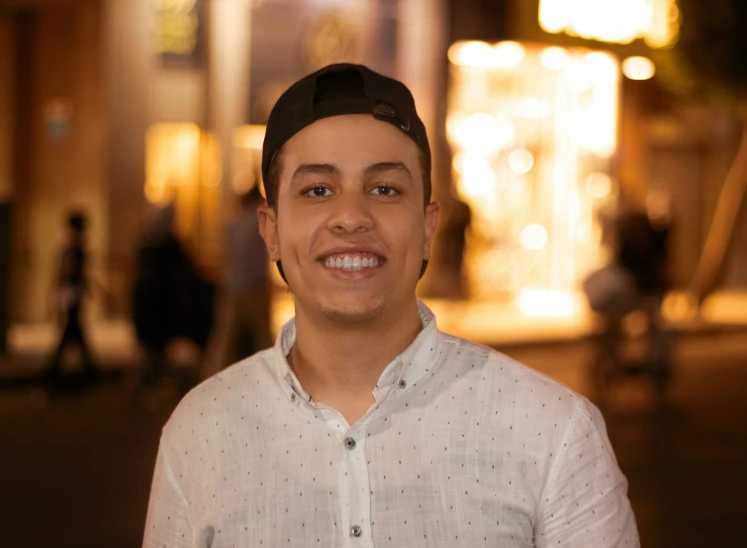 a man is smiling while wearing a hat