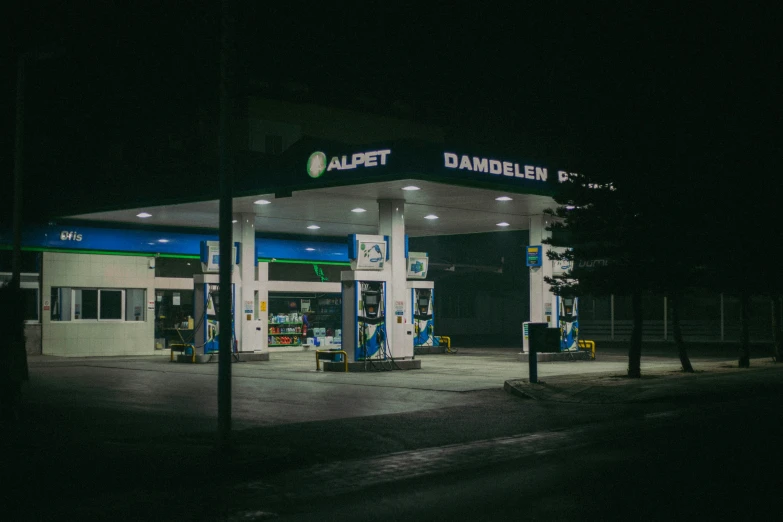 an illuminated gas station with a dark sky