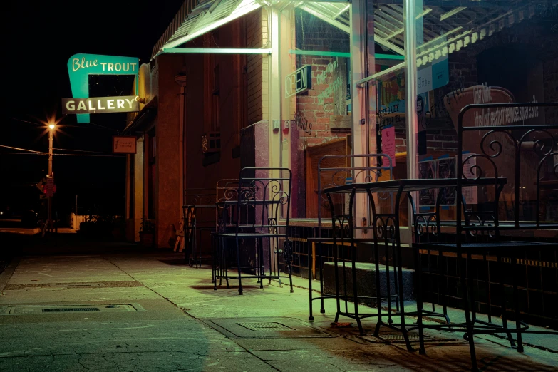 an alleyway has neon lights and closed bars