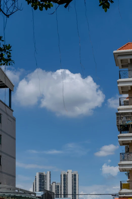 two buildings with balconies and some clouds above