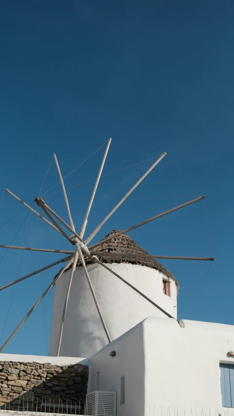 a large white windmill is sitting near a building