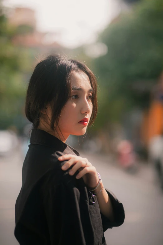 a girl standing on the street staring at soing