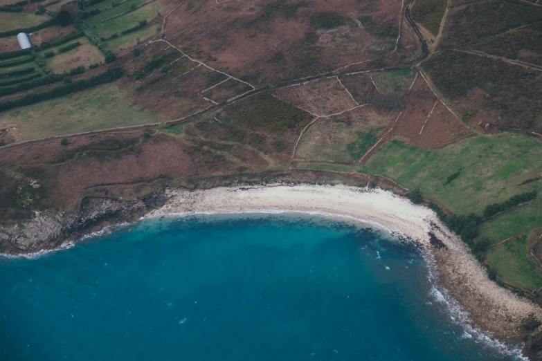 an aerial po of a beautiful blue ocean with white sand