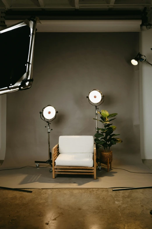 a small white chair is in front of spotlights