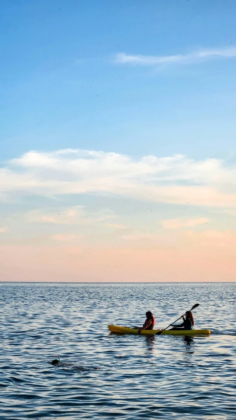 people in a boat in the water during sunset