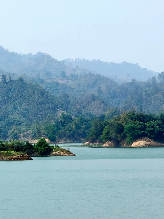 a boat sailing in a large lake with a mountain in the background