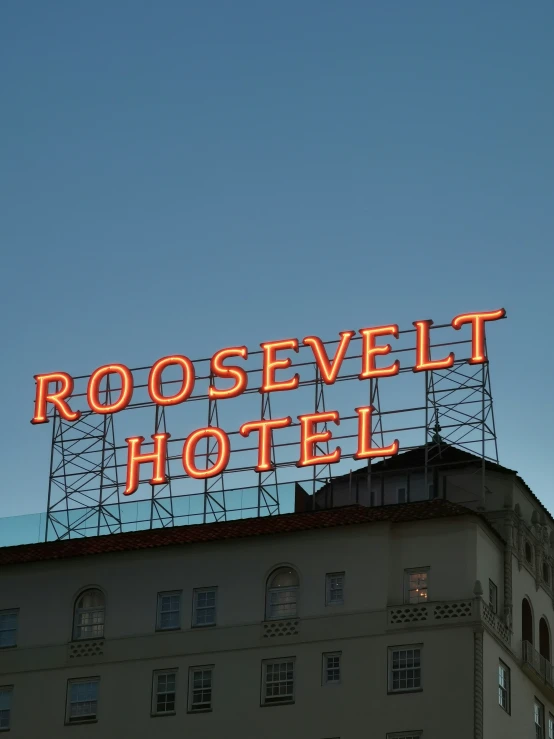 a neon sign that reads roosevelt el over the roof