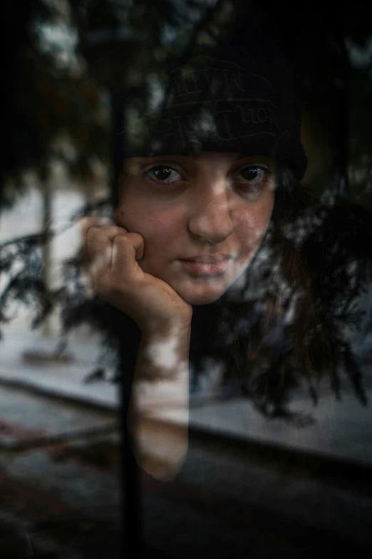 a woman posing with her hand on her shoulder looking out of the window