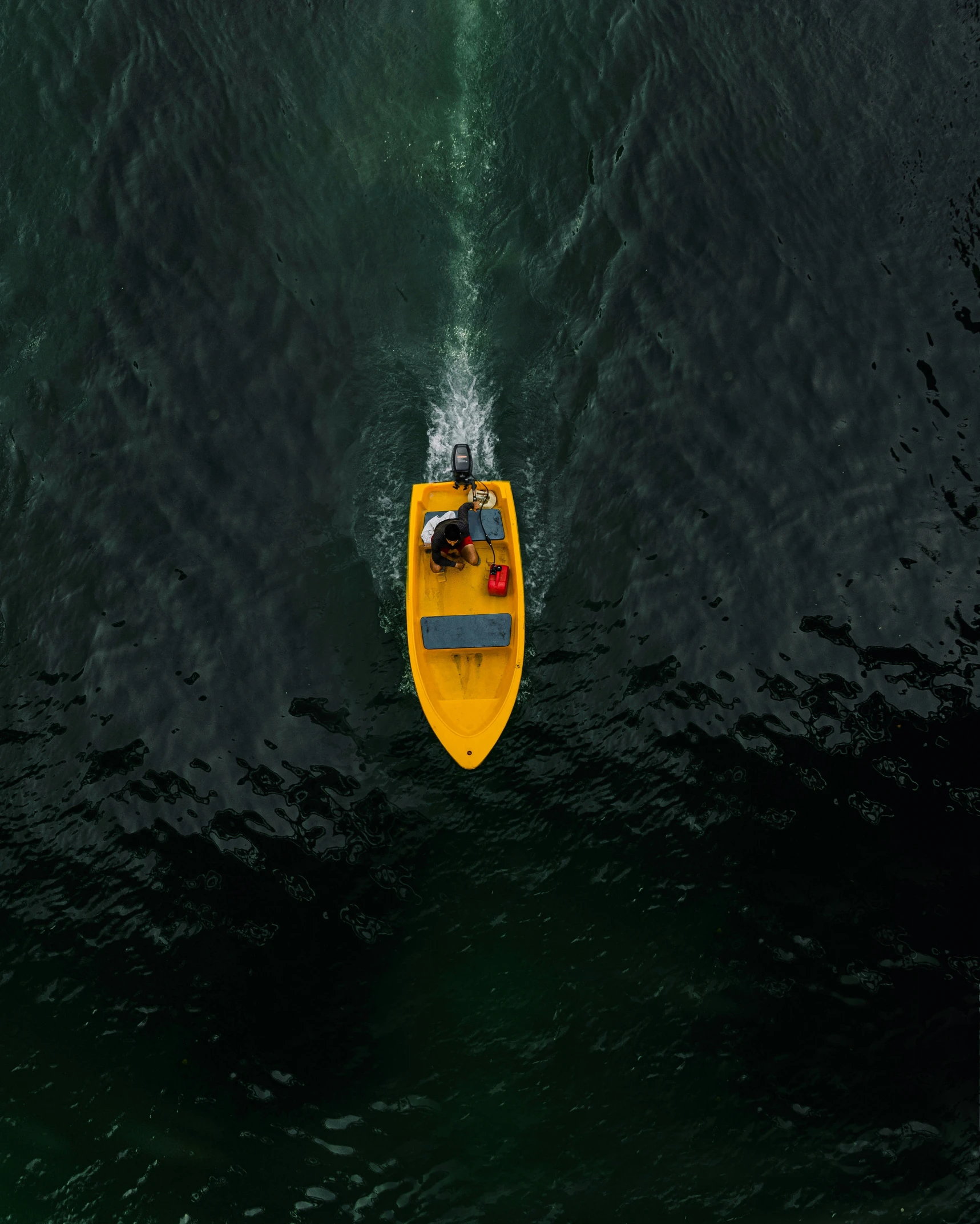 a yellow boat in the water with its paddle up