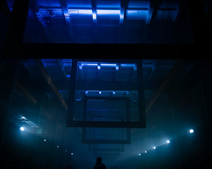 two people walking in the dark between blue lights