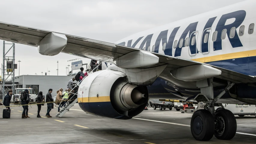 some people boarding a large airplane to take off