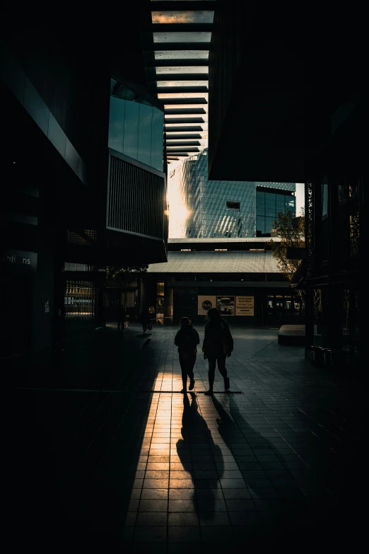 a group of people walking down a street under buildings