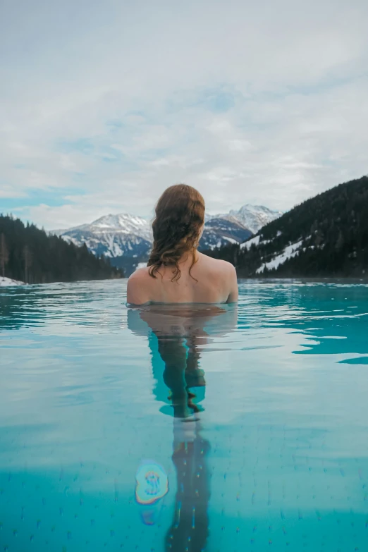 a girl is swimming in the water outside