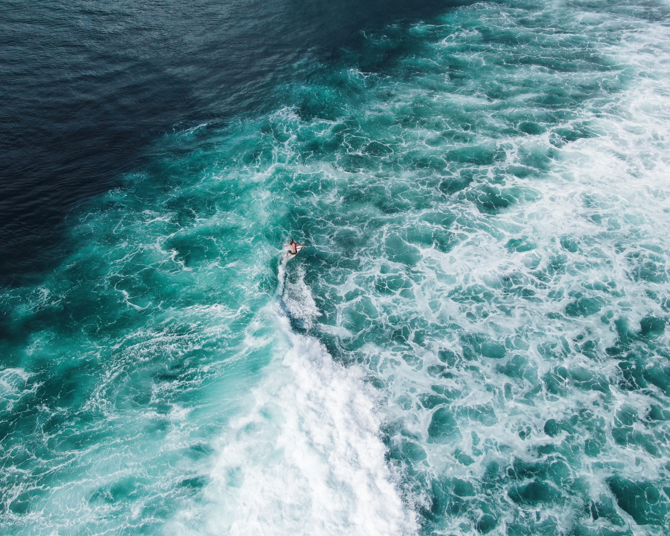 aerial view of water surfing, just before it breaks