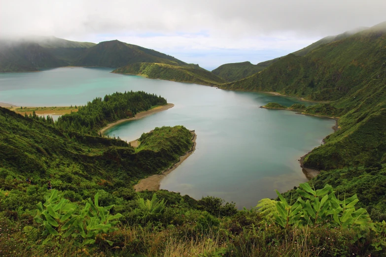 a group of mountains next to a large lake