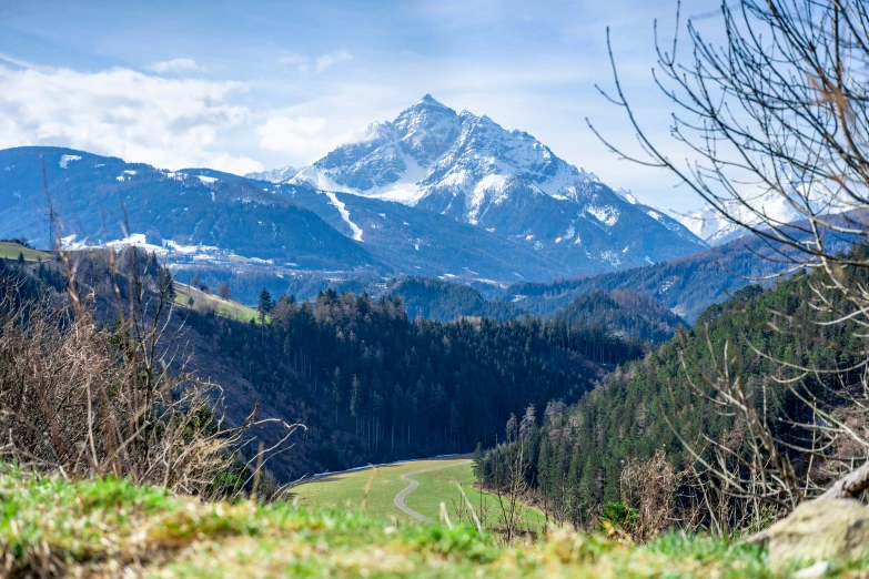 the mountains rise up high above a grassy valley