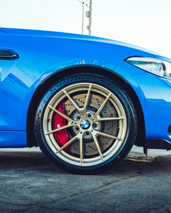 a bmw blue sports car with red spokes and a pair of ke pads