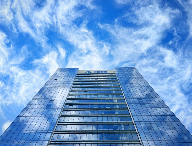 looking up at the sky and windows of an office building