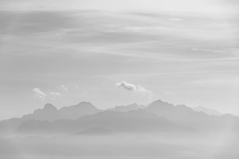 a black and white image of the view of a mountain range from an airplane