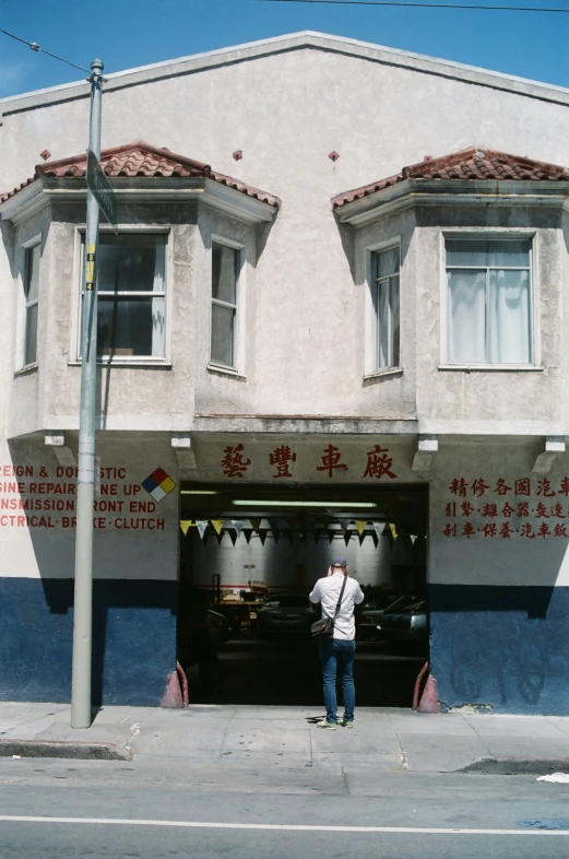 a man standing in front of a building with two windows