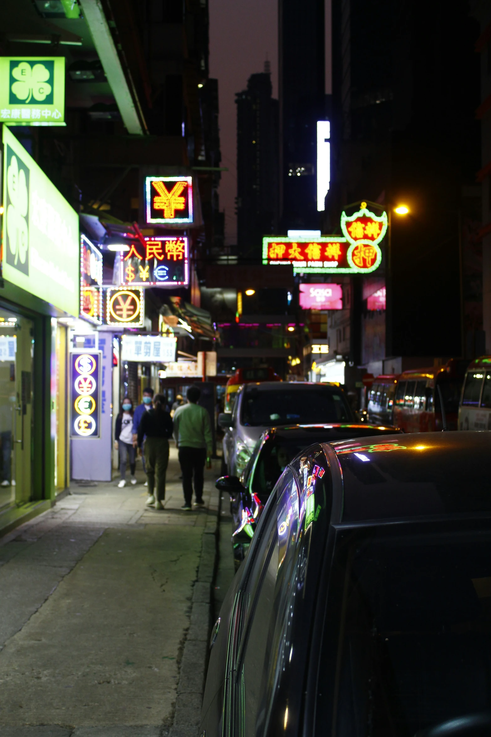 the cars and pedestrians are at night on the sidewalk