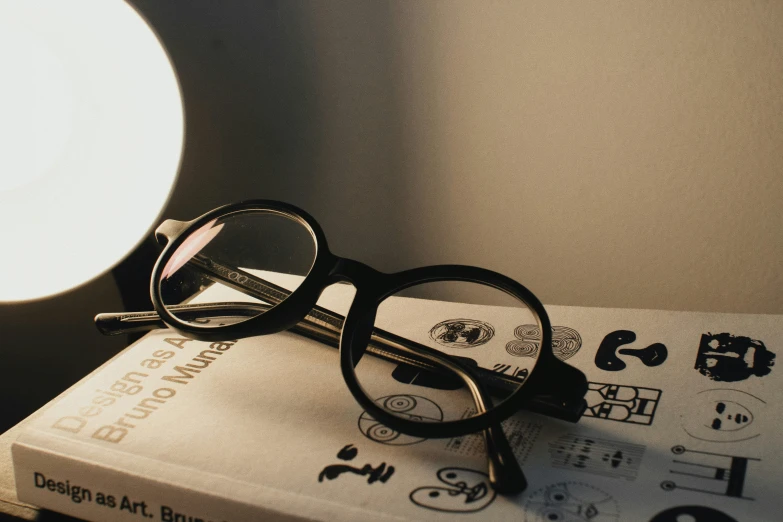a book is sitting next to a pair of glasses