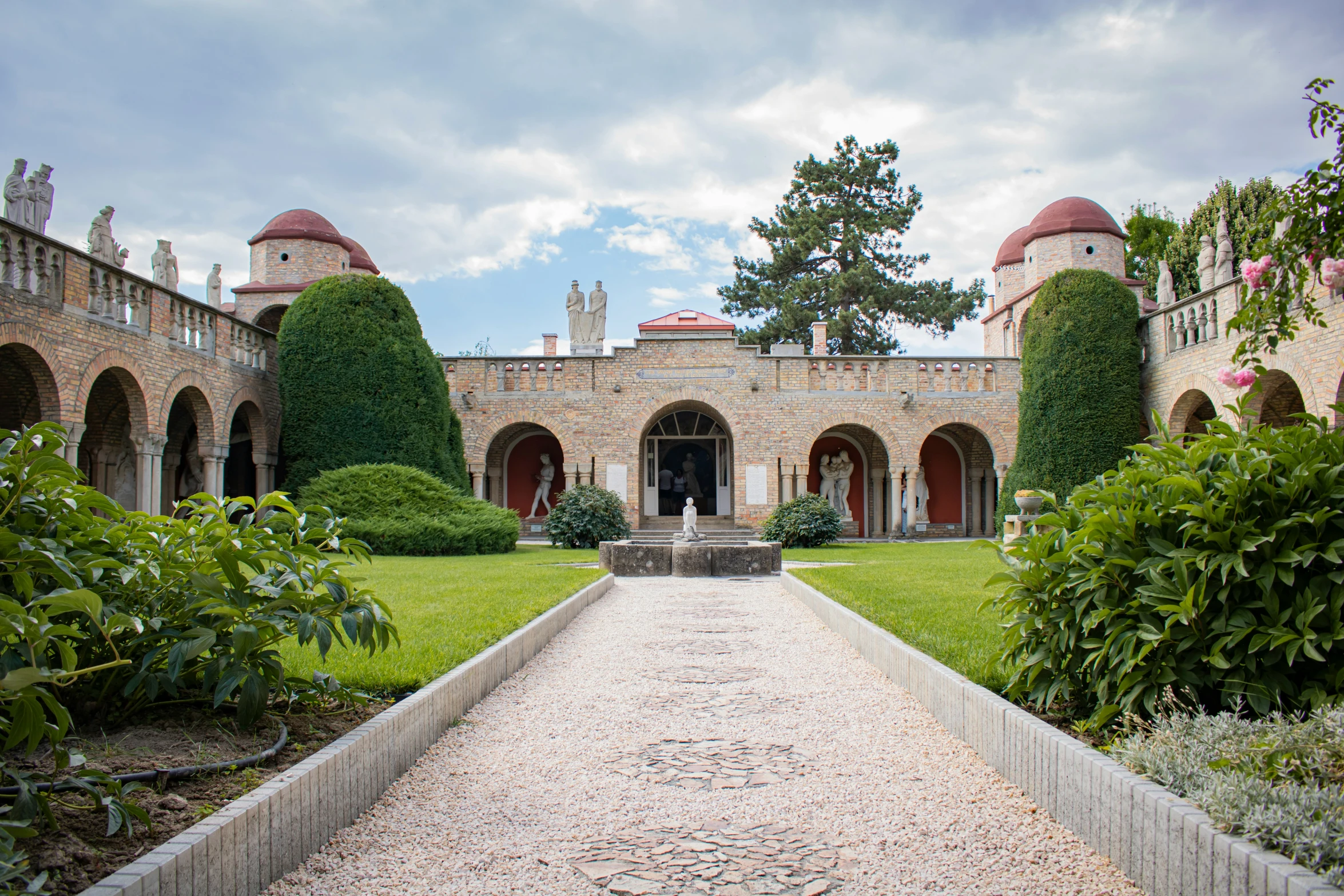 a walkway leading to a building with arches and pillars