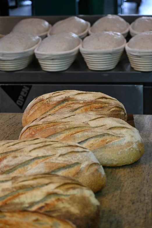 a table topped with bread next to bowls of donuts