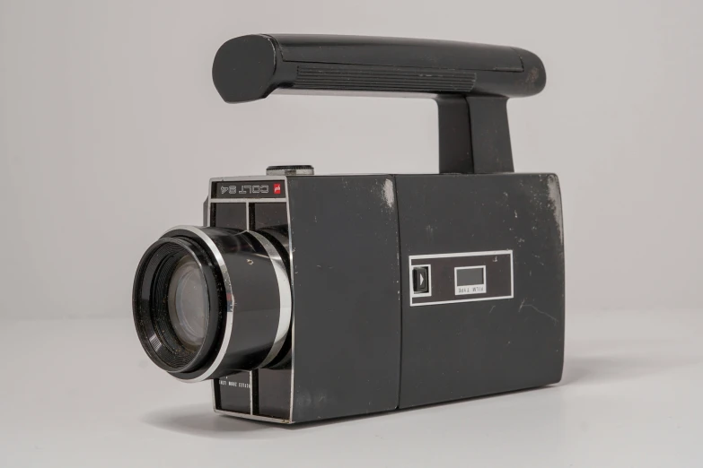 a brown film camera, with a long lens