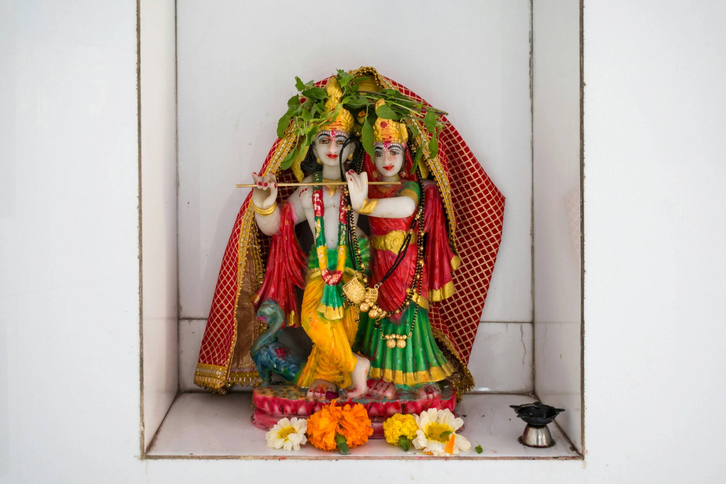 a statue of goddess siting on a shelf in the corner